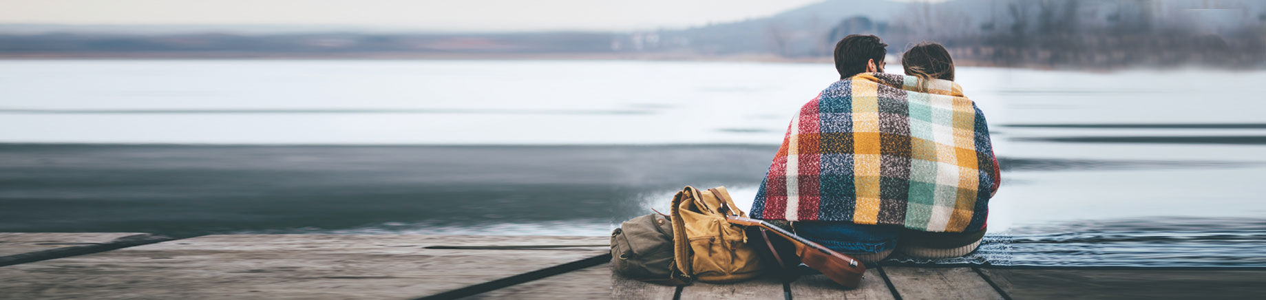 Couple together under blanket at lake