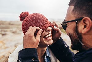 Man and Woman launghing pulling hat over her face