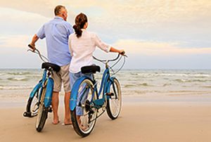 couples-man-and-woman-biking-on-beach