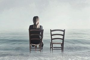 person sitting next to empty chair