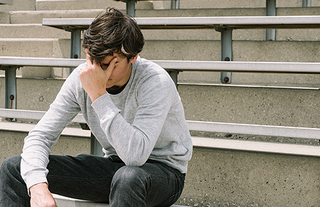 teen guy along on empty bleachers